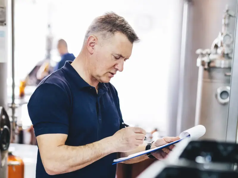 Man inspecting an industrial appliance.